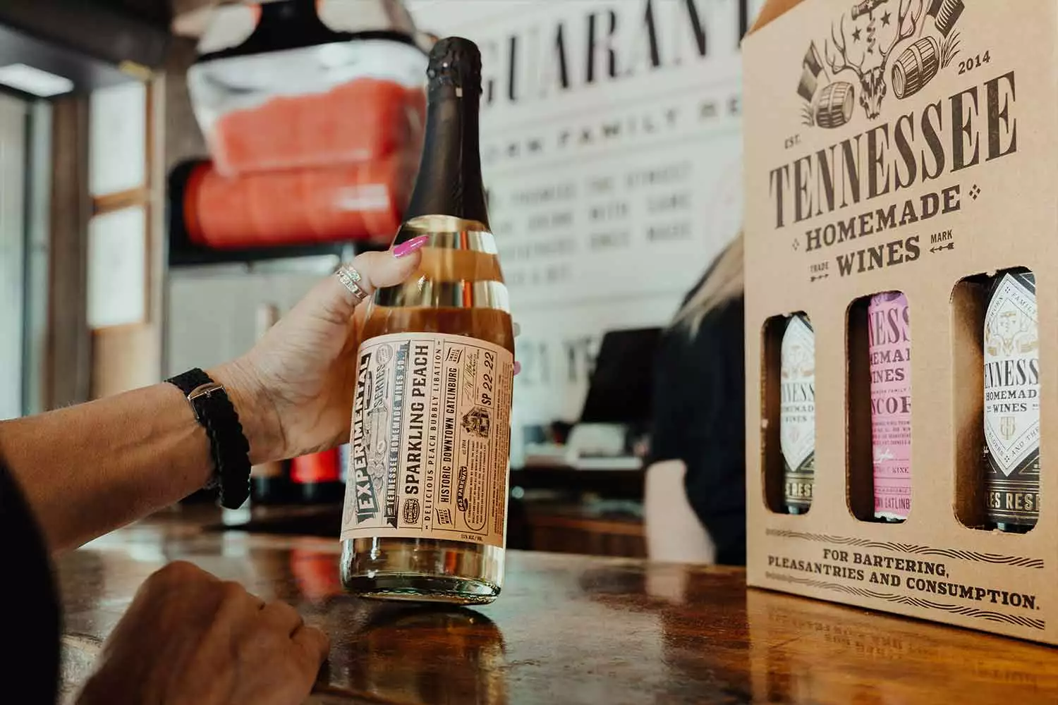 A customer holding a bottle from Tennessee Homemade Wines